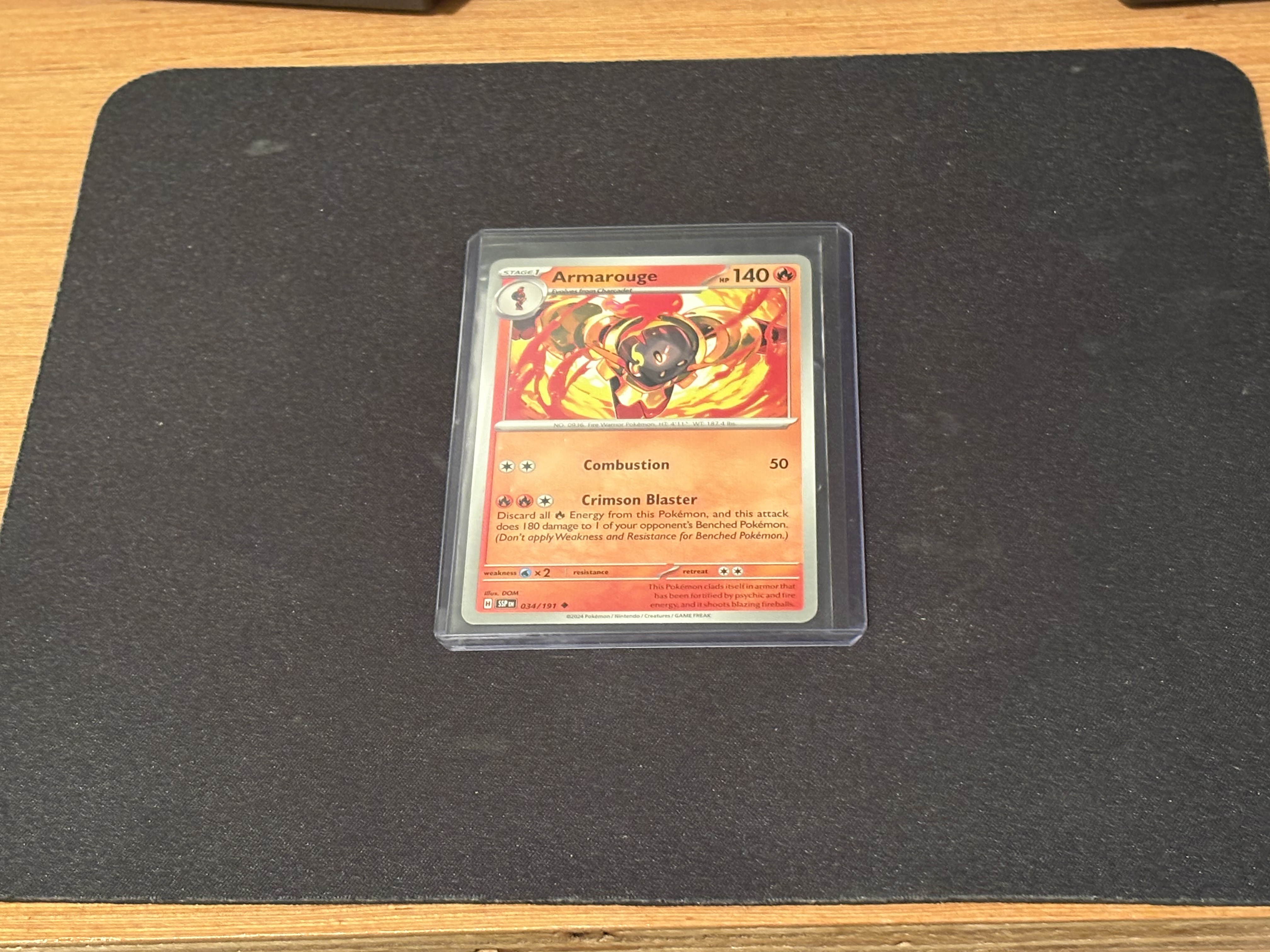 A sleeved card being inserted into a toploader